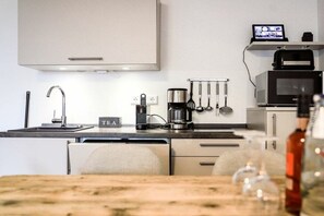 A modern kitchen with a stainless steel sink, a coffee maker, and a microwave. - Holiday apartment 603 (Winterberg)