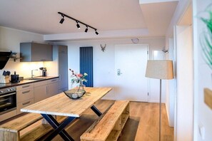 Eine moderne Küche mit Holztisch, Sitzbank und Pendelleuchte.