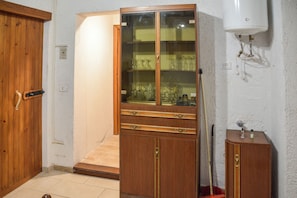 A room with a wooden cabinet, a glass display case, and a mop. - Tavernetta Openspace (Sparvo)