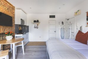 Ein gemütlicher Raum mit Bett, einer kleinen Küchenzeile und einem Essbereich.