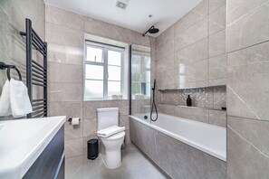 Ein modernes Badezimmer mit Badewanne, Toilette und Handtuchhalter.