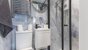 A bathroom with a toilet, sink, and shower.