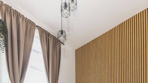 Quarto moderno com cama, parede de painéis de madeira e piso em padrão espinha de peixe.