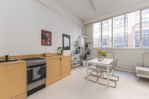Eine kleine Küche mit Herd, Backofen und einem Essbereich mit Tisch und Stühlen.