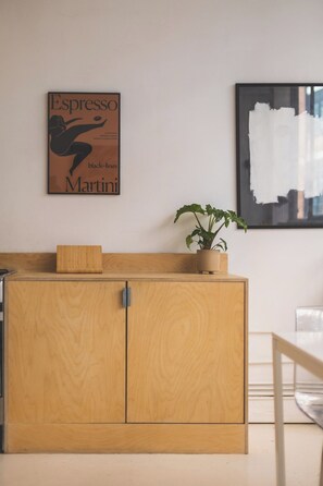 Eine Küche mit einem Holzkorpus, einer Topfpflanze und einem an der Wand befestigten Schild mit der Aufschrift Espresso.