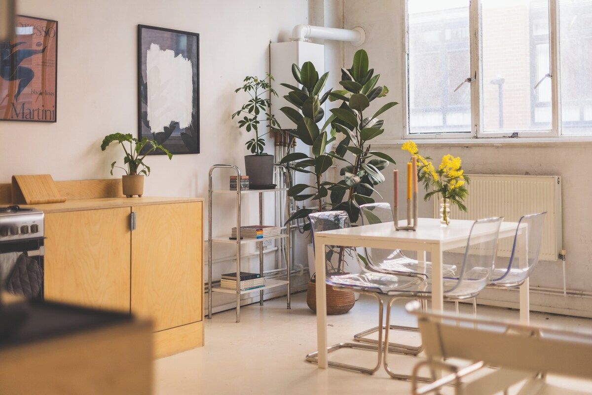 Una cocina moderna con armarios de madera, una estufa y un comedor con mesa y sillas.