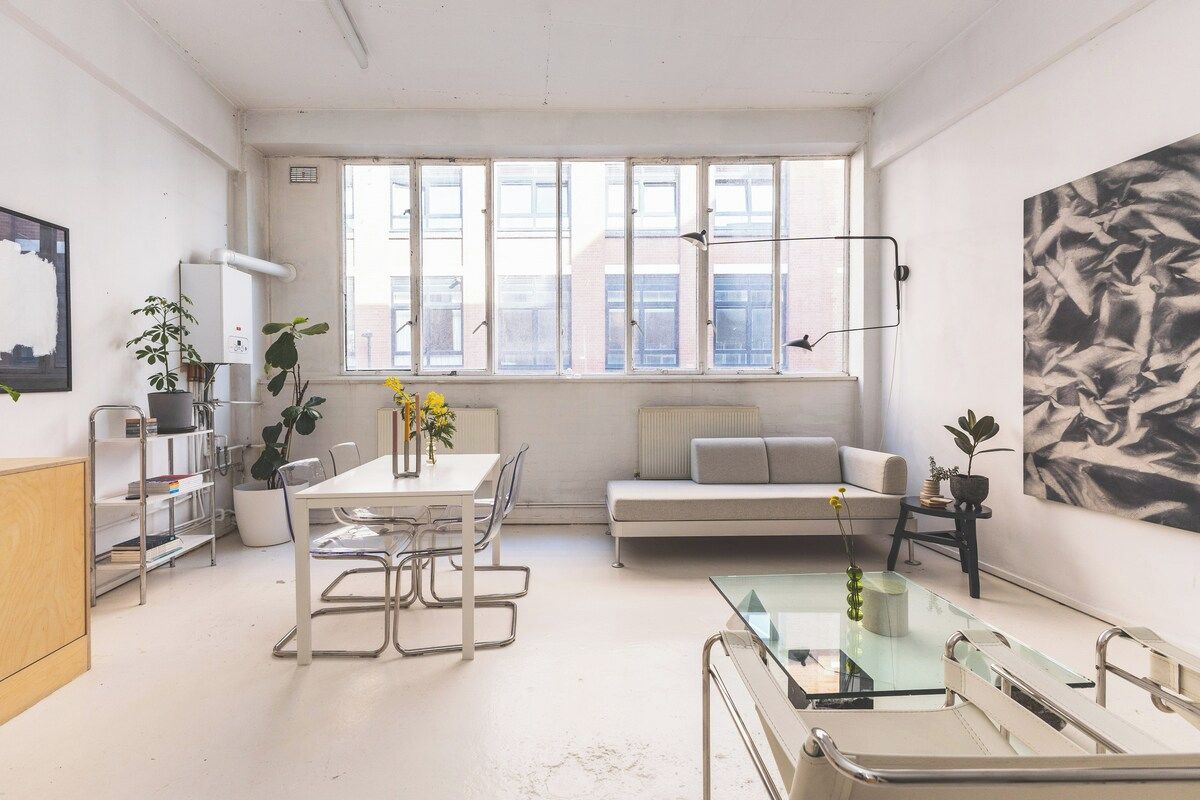 Un intérieur moderne comprenant un coin repas, un canapé et des œuvres d’art.