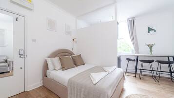 A bedroom with a bed, bedside tables, a desk, and a chair.