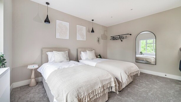 A bedroom with two beds, a bedside table, a mirror, and artwork on the wall. - Lovely 2BR Flat, 15Minutes to Wembley, Sleeps 5ppl (Greater London)