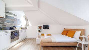 Una camera da letto moderna e funzionale con un letto in legno, un comodino e una TV a parete.