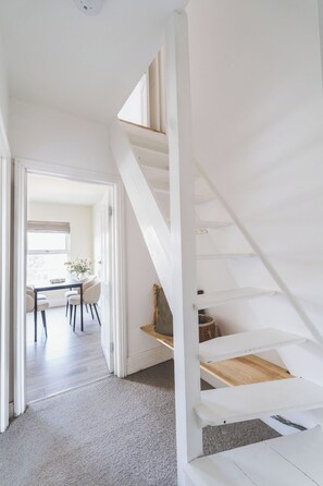 Ein modernes Interieur mit Treppe, Essbereich und Blick durch eine offene Tür.