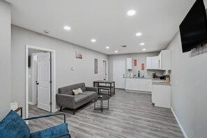 Eine moderne Wohnung mit Wohnzimmer, Küchenzeile und Essbereich.