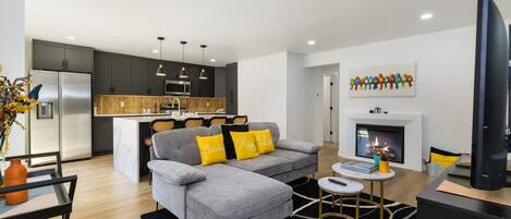 A modern living room with a grey sofa, a small coffee table, and a flat-screen TV.