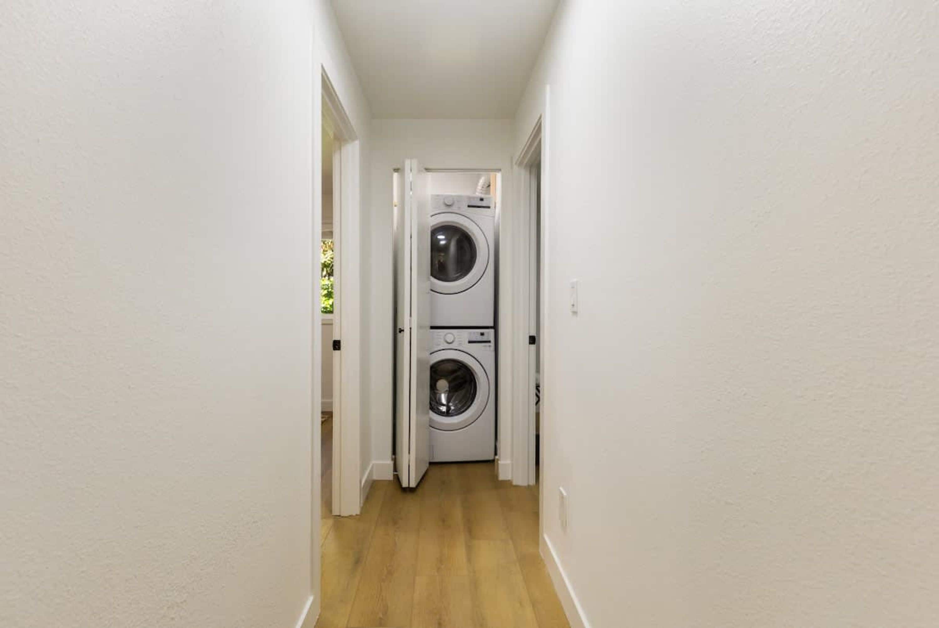 A narrow hallway with a double-door laundry room at the end.