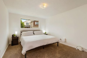 A bedroom with a single bed, two bedside tables, a nightstand, a window, and a ceiling light. - Cozy 2BR Home in Lynnwood w Backyard (Lynnwood)