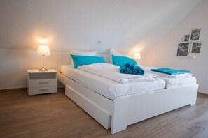 Una camera da letto con un letto, due comodini e una lampada a parete.