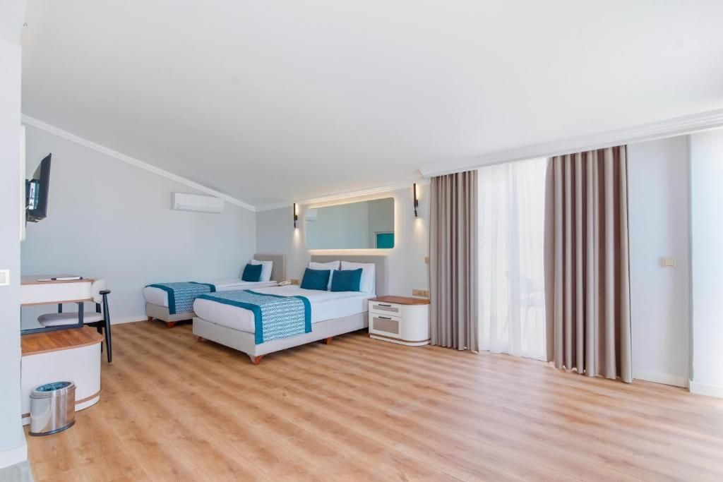Une chambre d’hôtel moderne équipée d’un lit, de tables de chevet, d’un bureau et d’une télévision.
