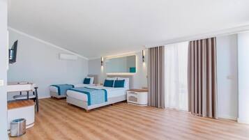 Une chambre d’hôtel moderne équipée d’un lit, de tables de chevet, d’un bureau et d’une télévision.