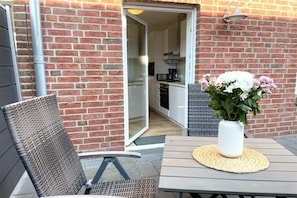 Eine Terrasse im Freien mit Tisch, Stuhl und einer Topfpflanze.