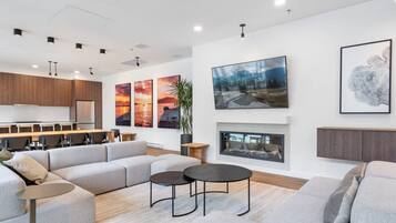 A modern living room with a sectional sofa, a fireplace, and artwork on the walls.