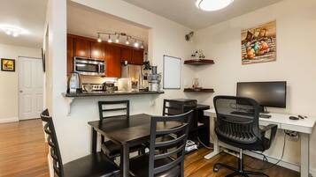 A compact living space with a kitchenette, dining area, and a workspace.