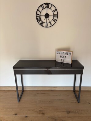 A black table with a clock and a sign on the wall behind it. - Fully renovated rural vacation rental (Pleyben)