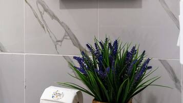 Bathroom 1: Clean marble tile and thoughtful finishes throughout.