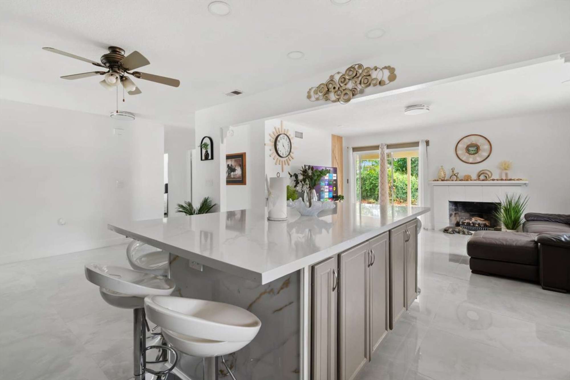 A large center island with bar seating looks straight out over the living area.