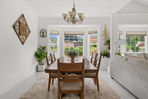 Gather around a large dining table beneath an elegant chandelier.