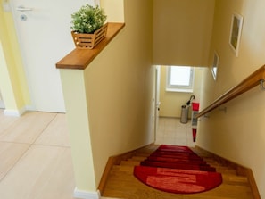 Eine Treppe mit einer Holzhandläufe und einem roten Teppich.