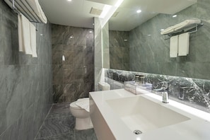 A modern bathroom with a large white sink, a toilet, and a shower area. - Canvas Hotel Pattaya (Pattaya)