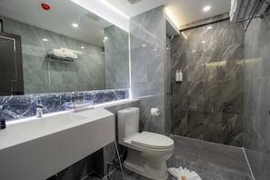 A modern bathroom with a marble vanity, a toilet, and a shower area. - Canvas Hotel Pattaya (Pattaya)