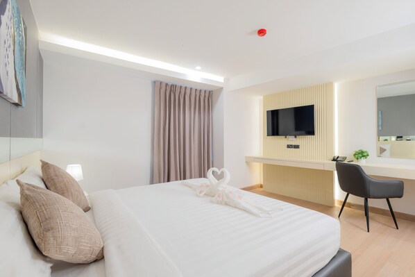 A hotel room with a bed, a desk, a chair, a TV, and a mirror. - Canvas Hotel Pattaya (Pattaya)