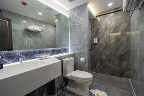 A modern bathroom with a marble vanity, a toilet, and a shower area. - Canvas Hotel Pattaya (Pattaya)