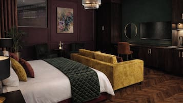 A hotel room with a bed, a sofa, a television, and a mirror.