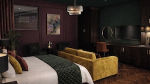 Ein Hotelzimmer mit Bett, Sofa, Fernseher und Spiegel.