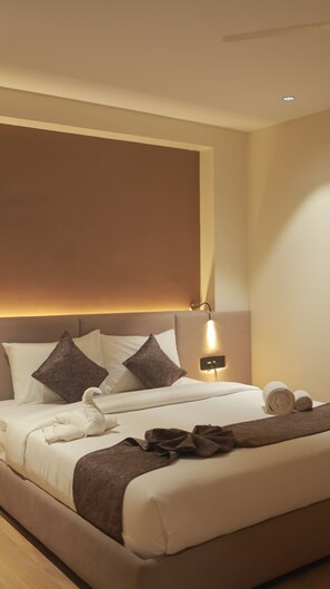 A hotel room with a large bed, a headboard with integrated lighting, and a bedside table with a lamp. - Swarup1 Business Hotel (Jabalpur, Madhya Pradesh)
