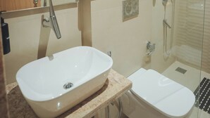 Un bagno moderno con uno specchio grande, un lavandino, un bidet e una doccia.