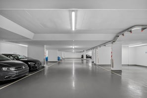 Un aparcament de diversos pisos, amb places de pàrquing senyalitzades i un ambient net i ben il·luminat.