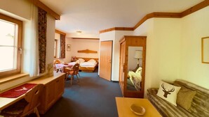 Una habitación con cama, escritorio, silla, sofá y espejo.