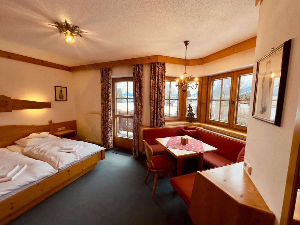 A room with a bed, a table, and a bench.