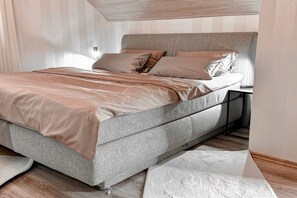 A modern bedroom with a bed, nightstand, and a view of the outside. - Holiday apartment with 2 bedrooms (Bad Harzburg)