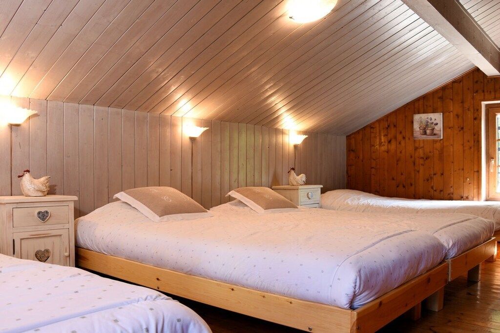 Ein Zimmer mit drei hölzernen Betten, jeweils mit einem passenden Nachttisch und einer kleinen Dekoration.