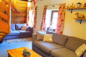 A cozy living room with a sofa, a coffee table, and a staircase. - Alpine hut in CHATEL with barbecue (CHATEL)