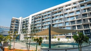 Een modern hotel met een centrale binnenplaats, een zwembad en een overdekt zitgedeelte.