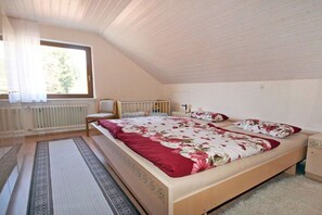 A bedroom with a single bed, a chair, a radiator, and a window. - Holiday apartment with 2 bedrooms (Schramberg-Tennenbronn)