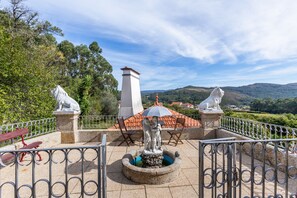 Un giardino con statue, una fontana e vista sulle colline.