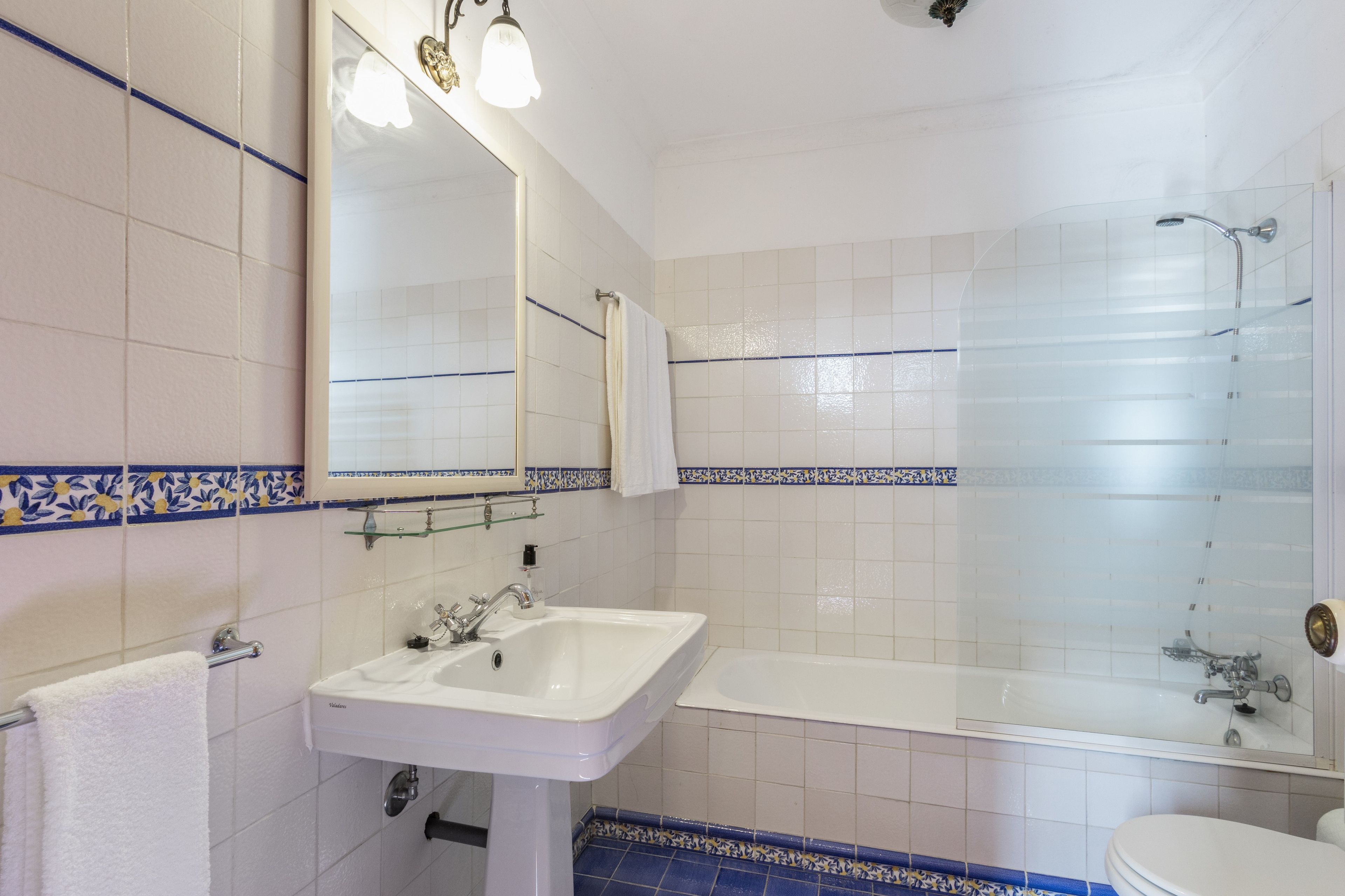 Un baño con un lavabo blanco, un espejo, una bañera y una ducha.