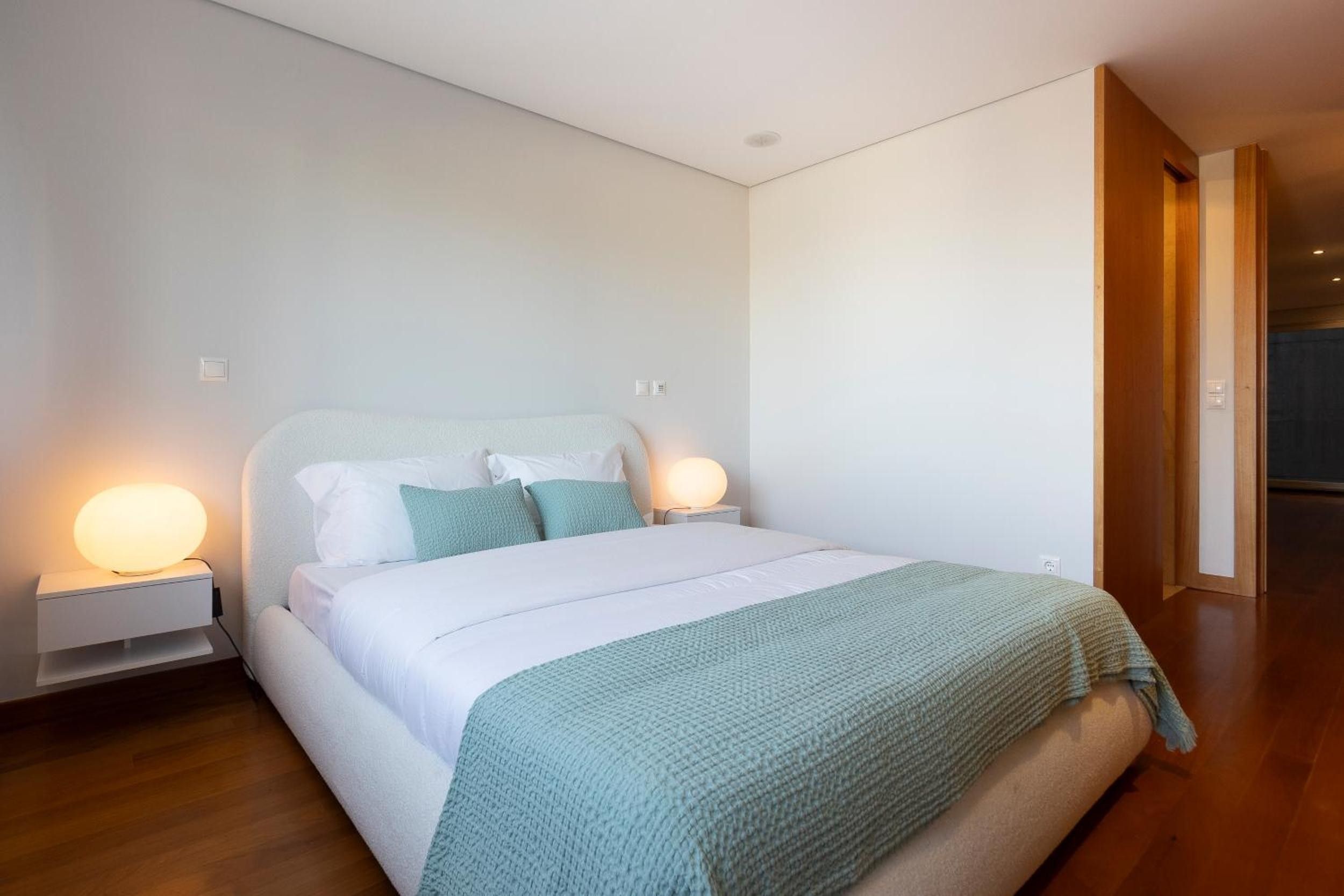 Un dormitorio moderno con una cama individual, dos mesitas de noche y una mesita auxiliar.