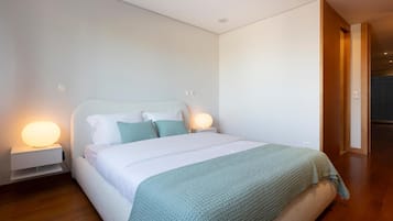Un dormitorio moderno con una cama individual, dos mesitas de noche y una mesita auxiliar.